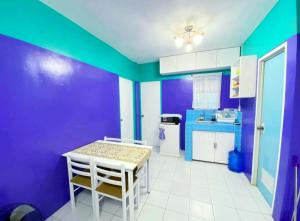 a kitchen with purple and green walls and a table and chairs at Kalai's Rental Dwellings (KRD) in Cotcot