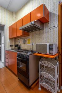 a kitchen with orange cabinets and a stove top oven at Estilo em Copacabana - Próximo a praia - BR403 Z4 in Rio de Janeiro