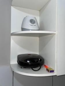 a black appliance is sitting on a shelf at Apartamento do Walisson in Guaramiranga