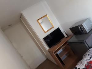 a small room with a television and a mirror at BluepointPH in Abbey Wood