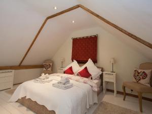 a bedroom with a bed and two chairs in a attic at The Barn in Burley