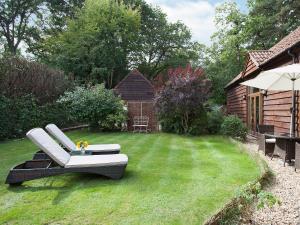 a garden with a black and white couch on the grass at The Barn in Burley