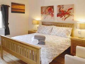 a bedroom with a bed with two night stands and two lamps at The Top Barn in Coedana