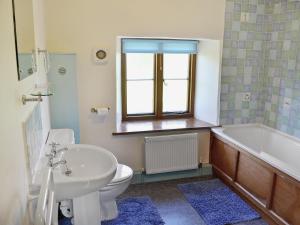 a bathroom with a sink and a toilet and a tub at Strawberie Cottage - E2390 in Stoke Abbott