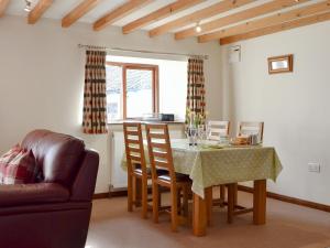 a living room with a table and chairs and a couch at Ash Tree Cottage in Gillamoor