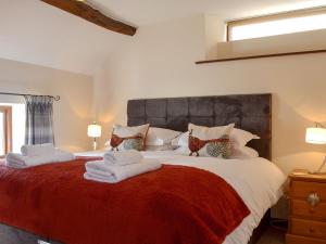 a bedroom with a large bed with towels on it at Ash Tree Cottage in Gillamoor