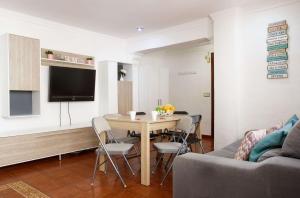 a living room with a table and chairs and a television at Luchana Apartment in Málaga
