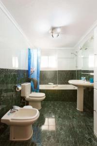 a bathroom with two toilets and a sink and a tub at Luchana Apartment in Málaga