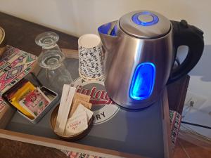 uma chaleira sobre uma mesa com uma luz azul sobre ela em A casa di Lu' elegant room em Monterotondo