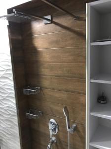a bathroom with a shower with wooden walls and shelves at The My Hotel in Umraniye