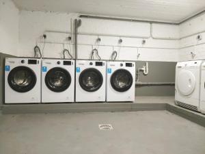 eine Waschküche mit vier Waschmaschinen sowie einer Waschmaschine und einem Trockner in der Unterkunft Tolstov Apartments - City Apartments with 1 or 2 Rooms - 15 Min to Messe DUS and Old Town DUS in Düsseldorf