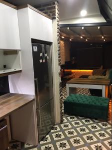 a kitchen with a refrigerator and a green ottoman at The My Hotel in Umraniye