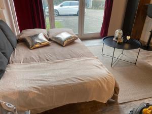 uma cama com duas almofadas e uma mesa num quarto em Le cinéma em Soultz-sous-Forêts