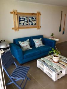 a blue couch and a chair in a living room at Laguna del Mar, acogedor Depa para 6 in La Serena