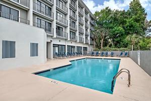a swimming pool in front of a building at Grand Hilton Head Inn, Ascend Hotel Collection in Hilton Head Island
