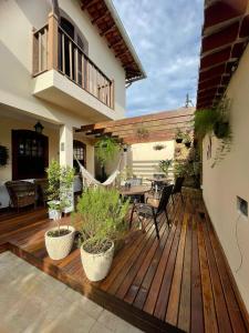 una terraza de madera con mesa y sillas. en Pousada Alecrim Dourado, en Paraty