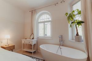a white bath tub in a bedroom with a window at Sonnenblick in Polanica-Zdrój