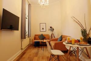 a living room with a couch and a table at Seagulls Nest- stylish 1 bed seafront apartment in Hastings
