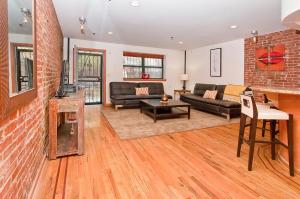a living room with a couch and a brick wall at 136TH UNIT 1 in New York