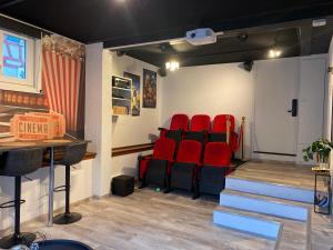 un teatro con sillas rojas en una habitación en Le cinéma, en Soultz-sous-Forêts