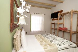 a bedroom with a bed and a chandelier at Pousada das Pedras in Passa Quatro