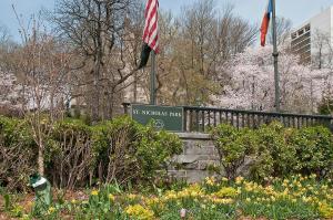 a park with a flag and a sign and flowers at 136TH UNIT 1 in New York