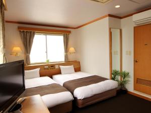 Un pat sau paturi într-o cameră la HOTEL LiVEMAX BUDGET Okinawa Tomariko