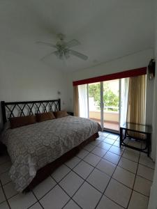 - une chambre avec un lit et un ventilateur de plafond dans l'établissement Villas del Palmar Manzanillo with Beach Club, à Manzanillo