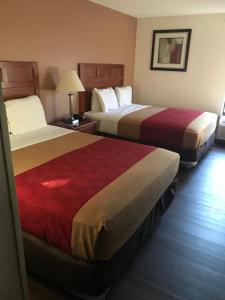 a hotel room with two beds and a lamp at The Best Inn & Suites in Markham