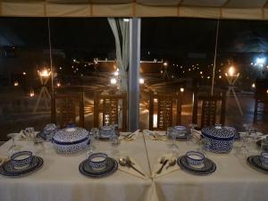 a table with blue and white dishes on it at Royal Luxury Camp in Merzouga