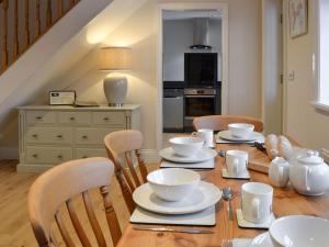 a dining room table with white dishes on it at Park Farm Cottage in Folkton