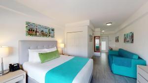 sypialnia z łóżkiem i niebieską kanapą w obiekcie Park Royal Miami Beach w Miami Beach