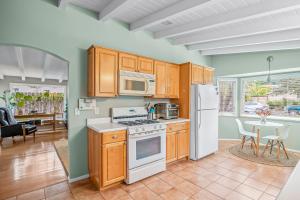 a kitchen with wooden cabinets and a white refrigerator at Casa Mesa in Santa Barbara
