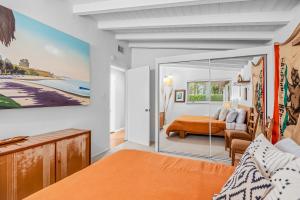 a bedroom with an orange bed and a mirror at Casa Mesa in Santa Barbara