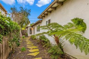 a house with a palm tree next to a sidewalk at Casa Mesa in Santa Barbara