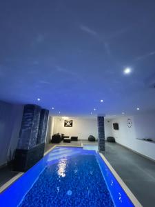 a swimming pool in a house with a blue ceiling at Imperial exclusive apartments in Velika Kladuša