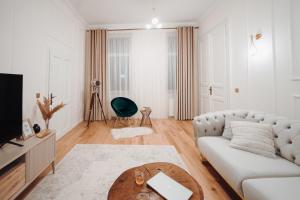 een woonkamer met een witte bank en een tafel bij Fabulous and Fancy City Center Designer Apartment in Cluj-Napoca