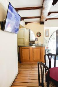 a kitchen with a table and a tv on the wall at Hotel Rondó in Viña del Mar