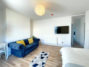 a living room with a blue couch and a tv at 2 Bed Gem Margate, Free Parking in Kent