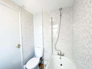 a white bathroom with a shower and a toilet at 2 Bed Gem Margate, Free Parking in Kent