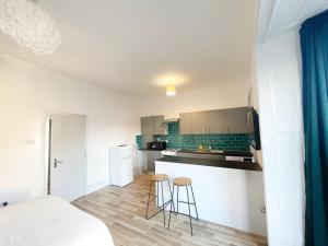 ein Schlafzimmer mit einem Bett und zwei Hockern vor einer Küche in der Unterkunft Margate 2 Bed, Prime Location in Kent