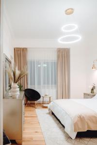 een witte slaapkamer met een bed en een raam bij Fabulous and Fancy City Center Designer Apartment in Cluj-Napoca