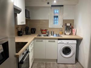a kitchen with a washing machine and a sink at Le cinéma in Soultz-sous-Forêts