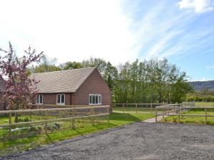 a barn with a fence and a house at Hornbeam Cottage in Great Malvern