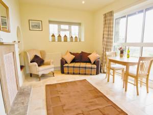 uma sala de estar com um sofá, uma mesa e cadeiras em Spring Cottage - Hw7734 em Tintern