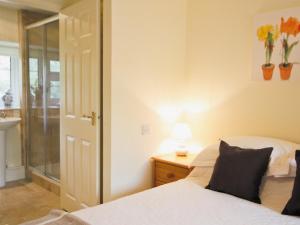 a bedroom with a bed and a lamp and a mirror at Spring Cottage - Hw7734 in Tintern