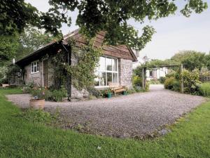 a stone house with a bench in front of it at Spring Cottage - Hw7734 in Tintern