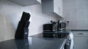 a kitchen with a knife block on the counter at City service Apartment in Beeston
