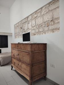 a television on top of a wooden dresser in a room at Villa con piscina mozzafiato, giardino e barbecue in Polignano a Mare