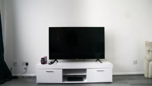 a flat screen tv sitting on a white entertainment center at City service Apartment in Beeston